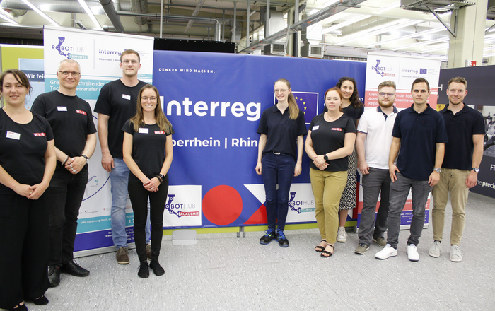 Eine Gruppe von Menschen mit dem Interreg-Logo im Hintergrund
