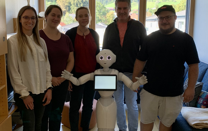 Besucher und Mitarbeiter mit dem Roboter Pepper
