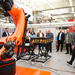 Menschen stehen um einen Industrieroboter herum